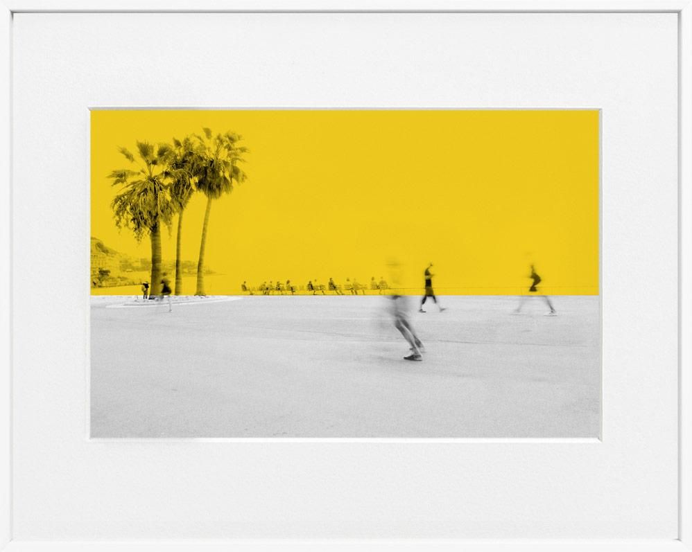A limited edition museum-quality photograph featuring a vibrant yellow sky with palm trees in the background, and a white foreground with silhouettes of people.
