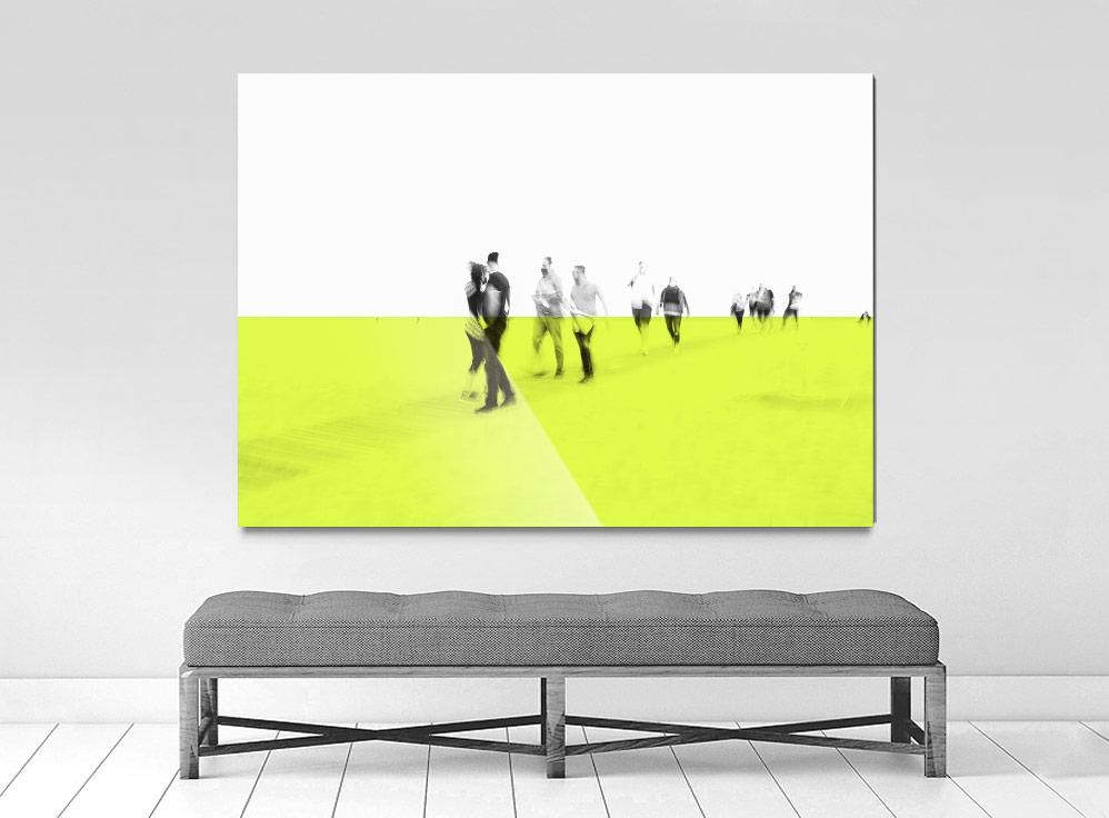 A framed limited edition museum-quality photograph depicting a group of people on a bright yellow surface with a white background, presented in a minimalist style.