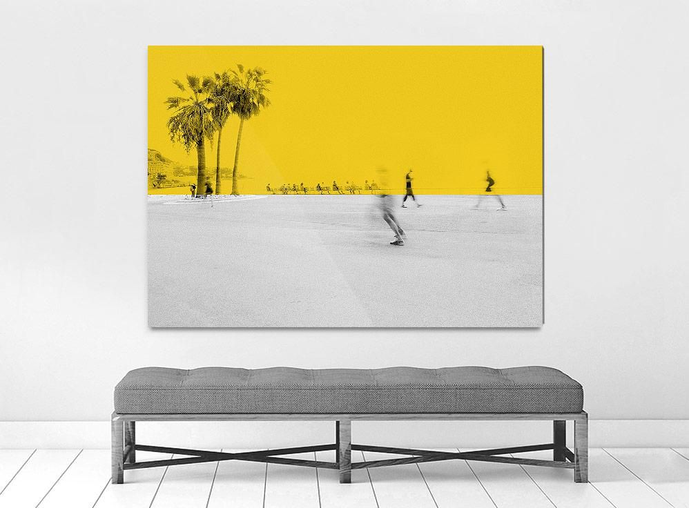 A limited edition museum-quality photograph featuring a vibrant yellow sky with palm trees in the background, and a white foreground with silhouettes of people.
