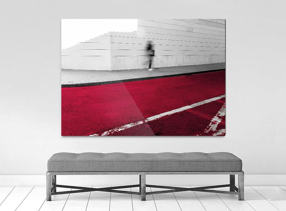 A limited edition museum-quality photograph featuring an abstract urban scene with a predominantly red color, a white geometric pattern, and a small figure in the distance. 