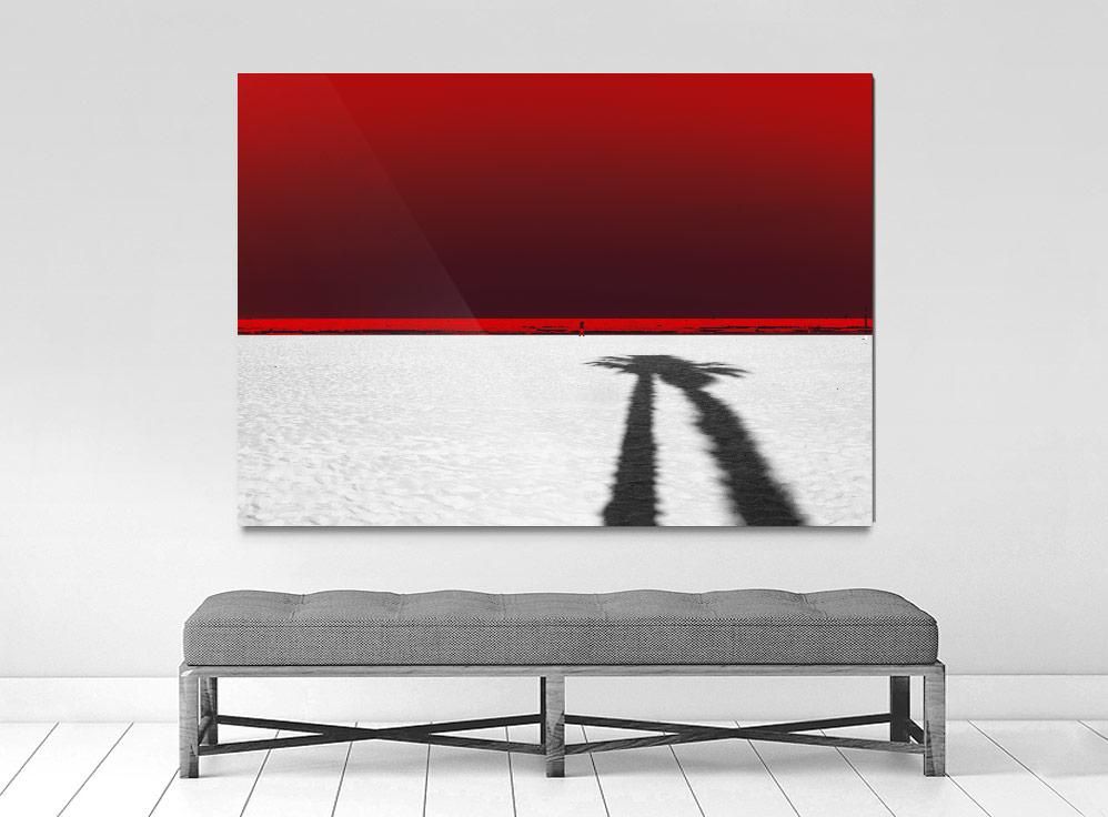 A limited edition museum-quality photograph featuring a red sky with a white lower half, and a shadow of a palm tree or similar shape in the center.