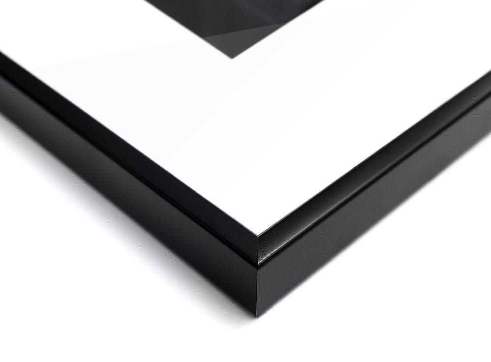 A close-up view of a black rectangular frame corner with a white surface and a partial dark geometric shape inside.