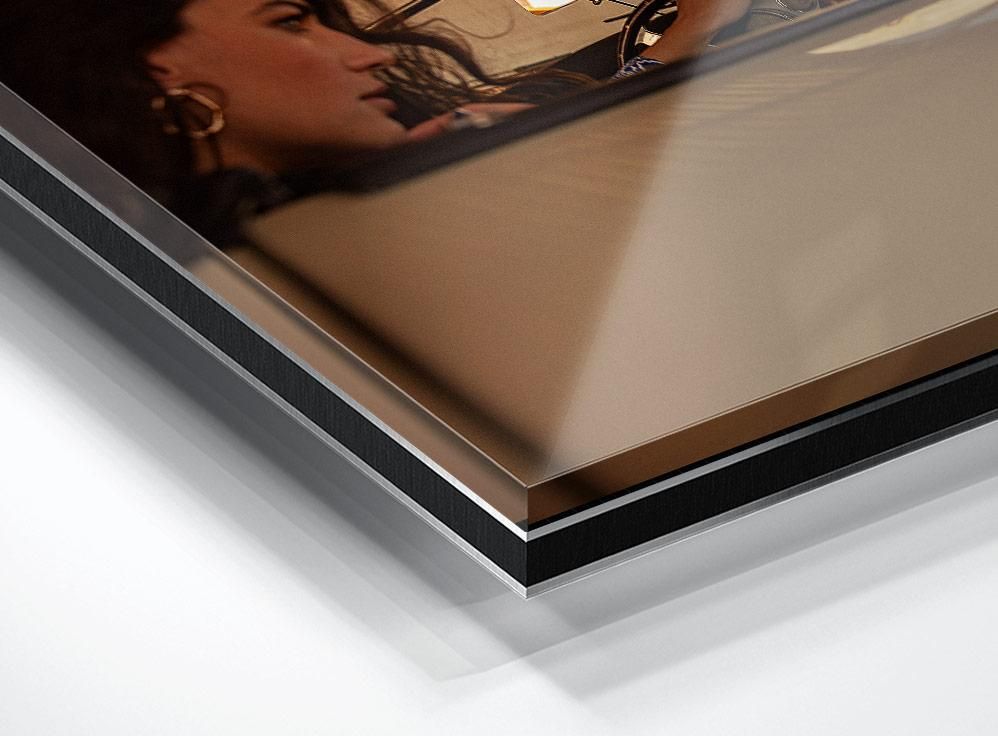 A cropped view of a woman’s face with dark hair and hoop earrings, partially visible behind a reflective surface at the image’s corner.