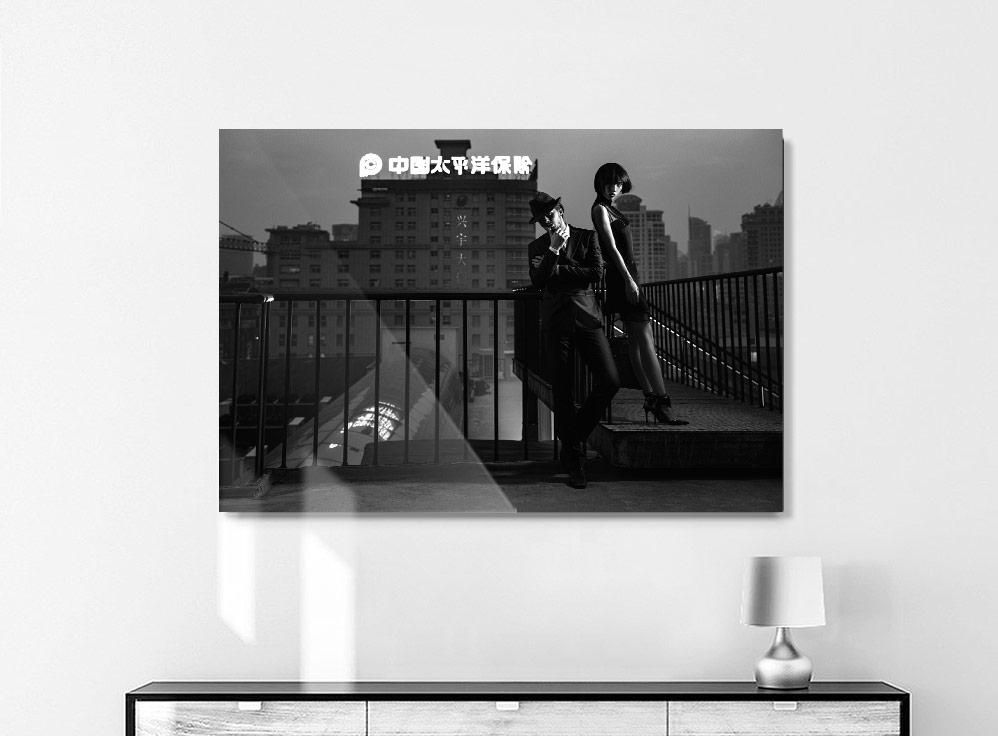 A black-and-white cityscape shows two people on an outdoor staircase with buildings and a lit sign in the background.